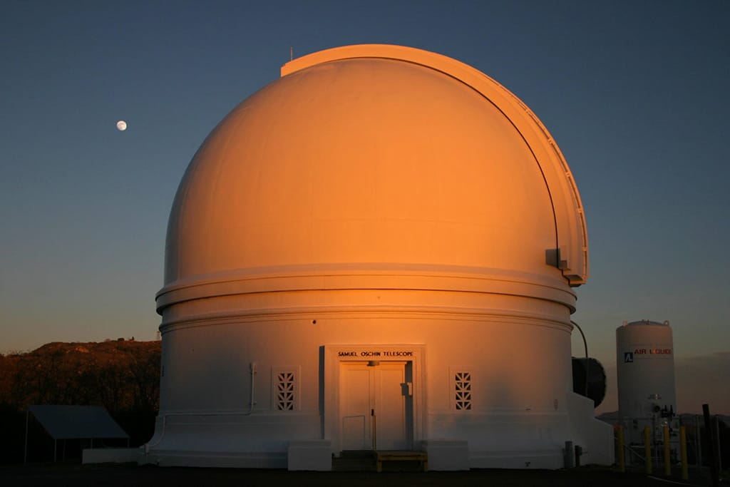 Cúpula del Telescopio Samuel Oschin en el Observatorio Palomar en San Diego, California, en un atardecer con luna.