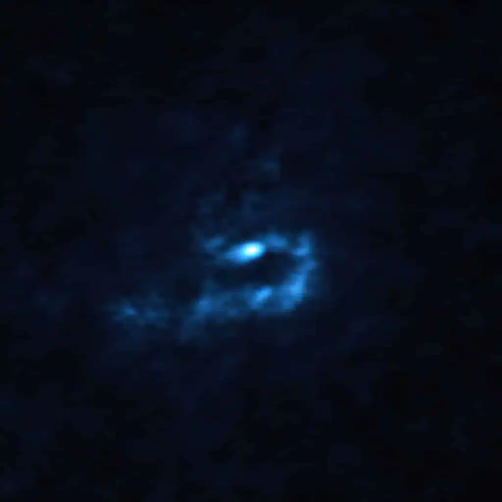 Esta imagen de la joven estrella V960 Mon y el material polvoriento circundante, se obtuvo con el Atacama Large Millimeter/submillimeter Array (ALMA), del cual ESO es socio. Grandes cúmulos de polvo con masas similares a las de los planetas son visibles aquí como manchas azules. Estos grupos podrían contraerse y colapsar a través de un proceso conocido como "inestabilidad gravitacional" para formar planetas gigantes del tamaño de Júpiter.