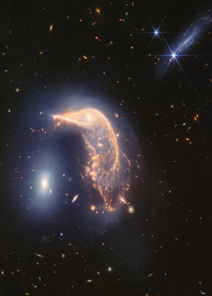 Imagen de Arp 142, el Pingüino y el Huevo, tomada por el telescopio espacial James Webb en infrarrojo cercano y medio para conmemorar su segundo año de actividad científica. Su interacción está marcada por un tenue resplandor azul en forma de U invertida.