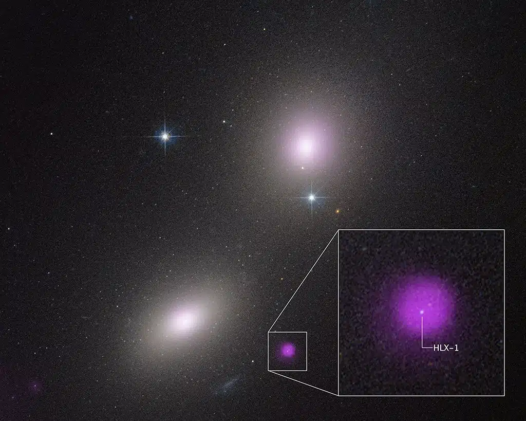Imagen del Telescopio Hubble de un par de galaxias: NGC 6099 (abajo a la izquierda) y NGC 6098 (arriba a la derecha). La zona de color violeta representa la emisión de rayos X de un cúmulo estelar compacto. Los rayos X son producidos por un agujero negro de masa intermedia que está desgarrando una estrella.