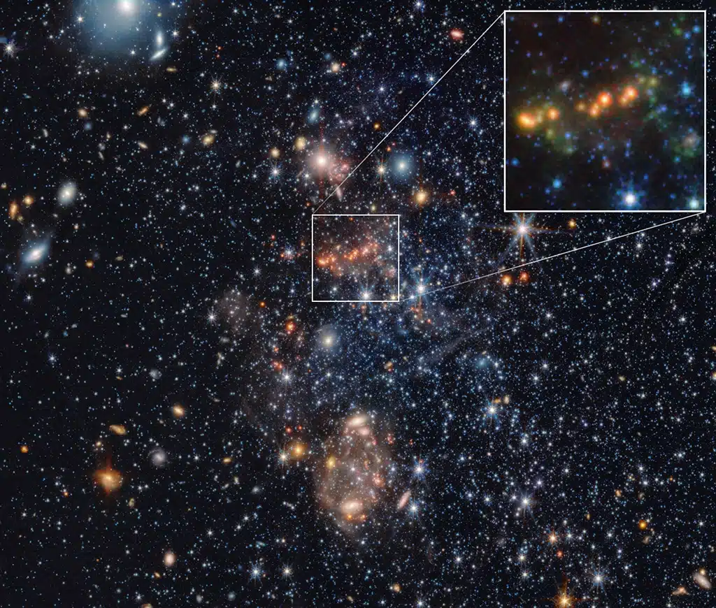 Imágenes de la galaxia enana Sextans A obtenidas por el telescopio espacial James Webb que revelan la presencia de hidrocarburos aromáticos policíclicos (PAH), grandes moléculas basadas en carbono que pueden ser un indicador de formación estelar. El recuadro ampliado en la parte superior derecha muestra con detalle estos PAH, representados en color verde. En Sextans A, los PAH aparecen agrupados en cúmulos y son relativamente pequeños.