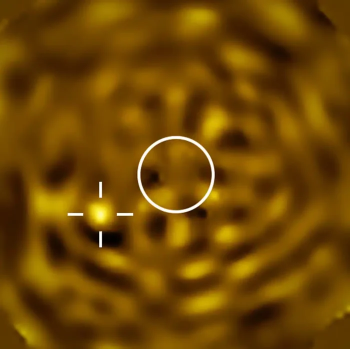 Imagen más nítida jamás conseguida de lo que probablemente sea Betelgeuse B, una estrella que orbita alrededor de Betelgeuse. Fue captada con el instrumento SPHERE del VLT en diciembre de 2024, cuando se preveía que la estrella compañera se encontrara a la mayor separación aparente de Betelgeuse vista desde la Tierra. El círculo indica el tamaño de Betelgeuse, cuya imagen ha sido eliminada. La brillante fuente de luz situada a la izquierda, señalada con una cruz, es Betelgeuse B.